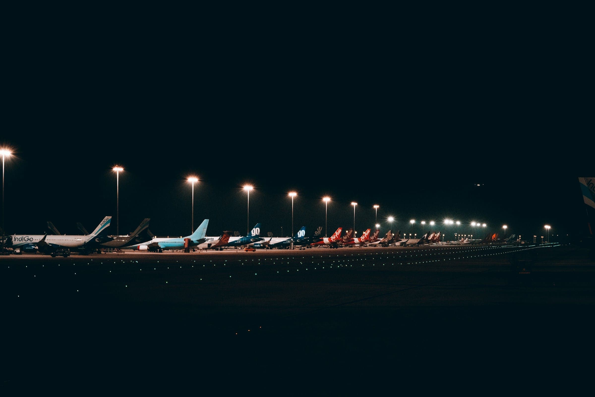 Airport apron with aircraft under lights at night