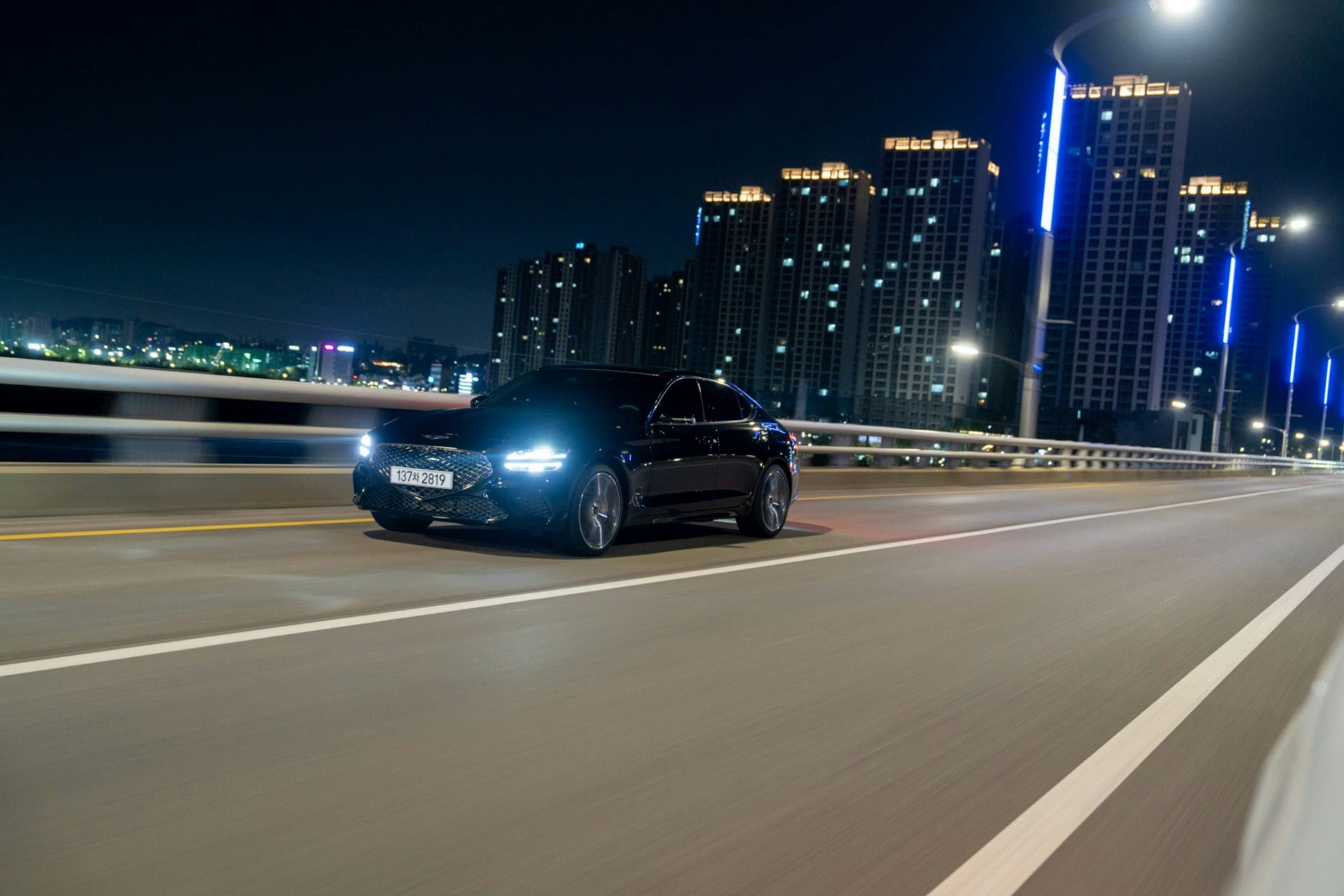 Black saloon moving through a city at night