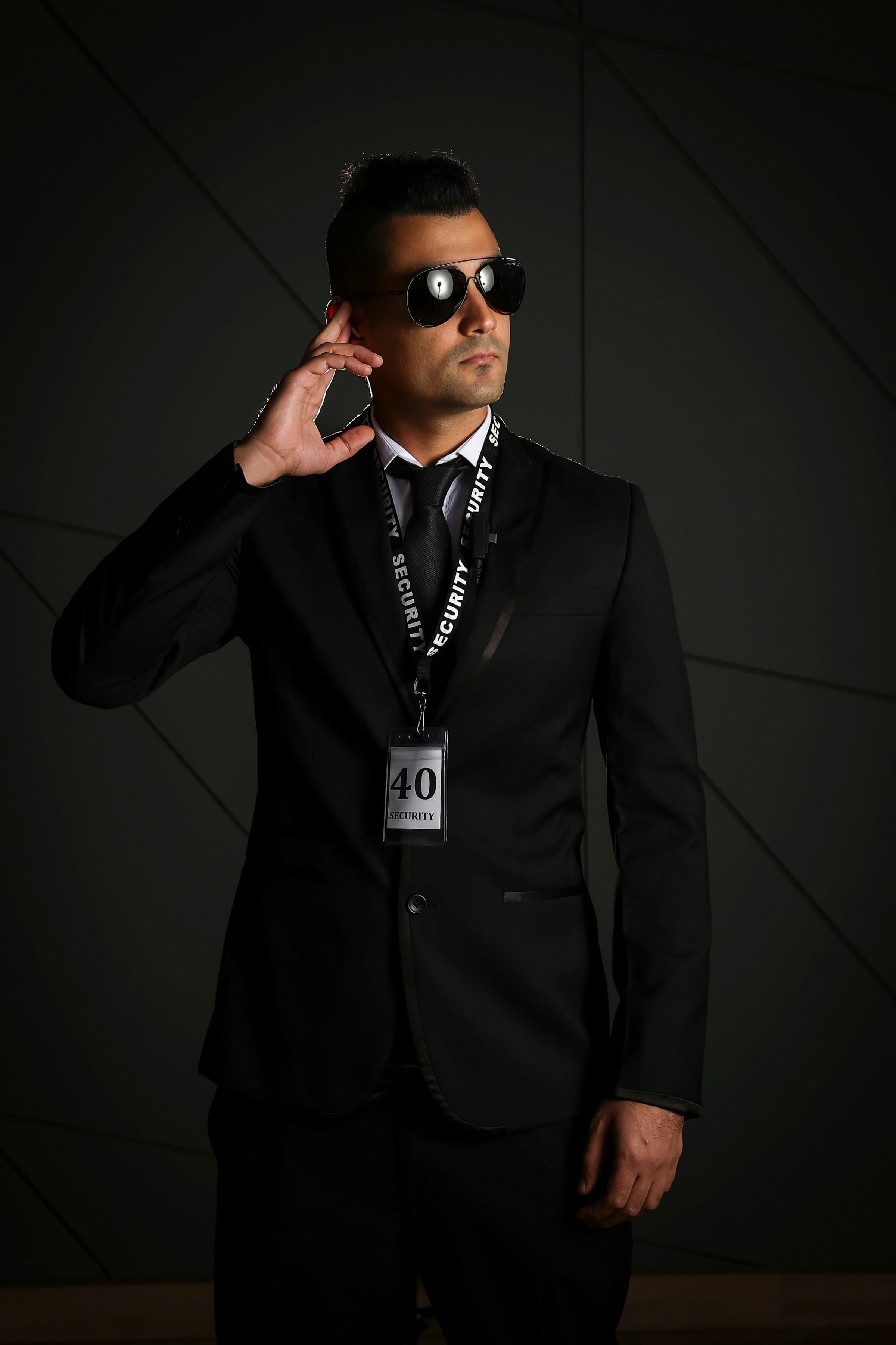 Security officer in a dark suit with earpiece and credentials